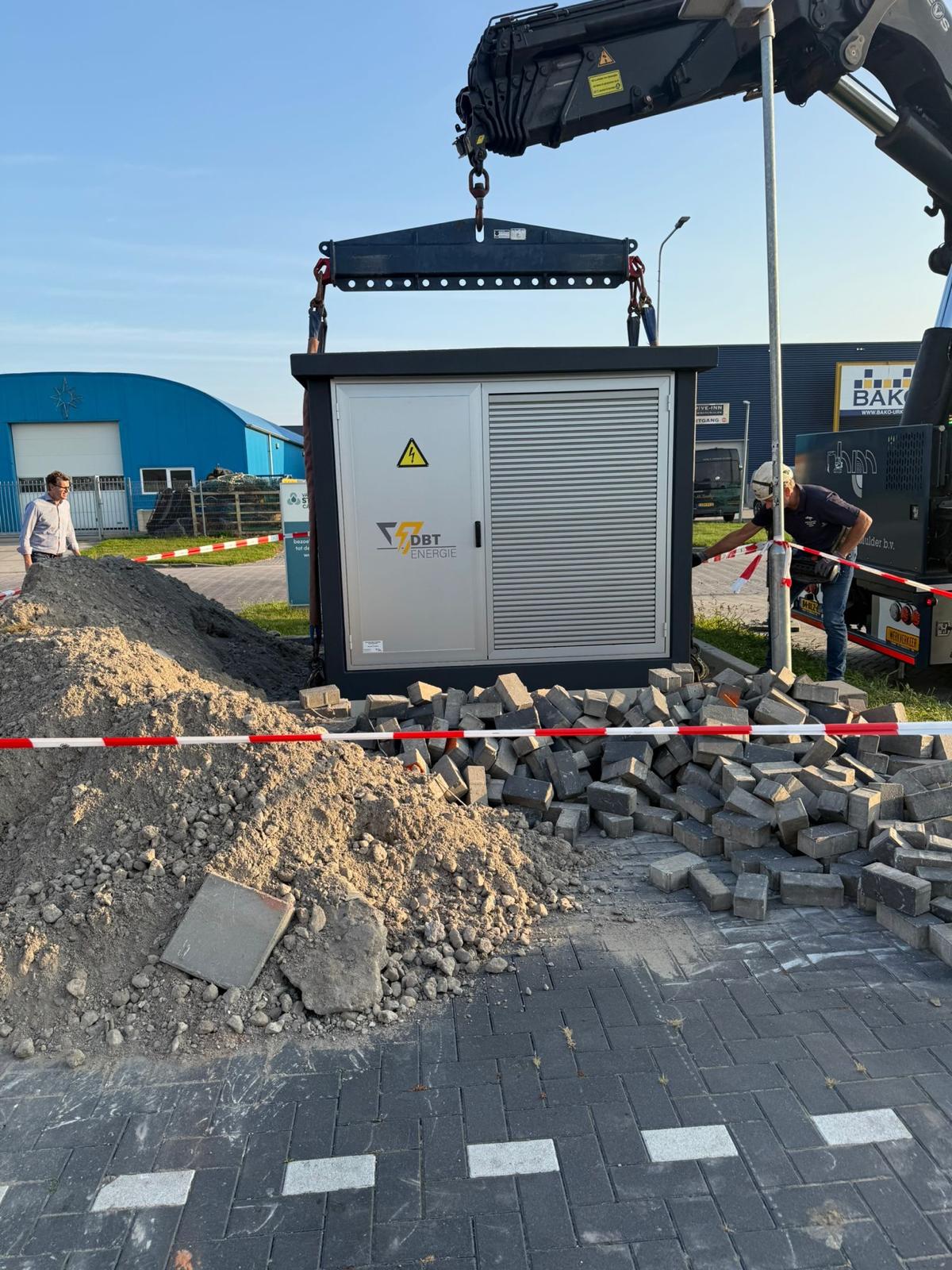 Compactstation van DBT Energie wordt met een kraan op de fundering geplaatst