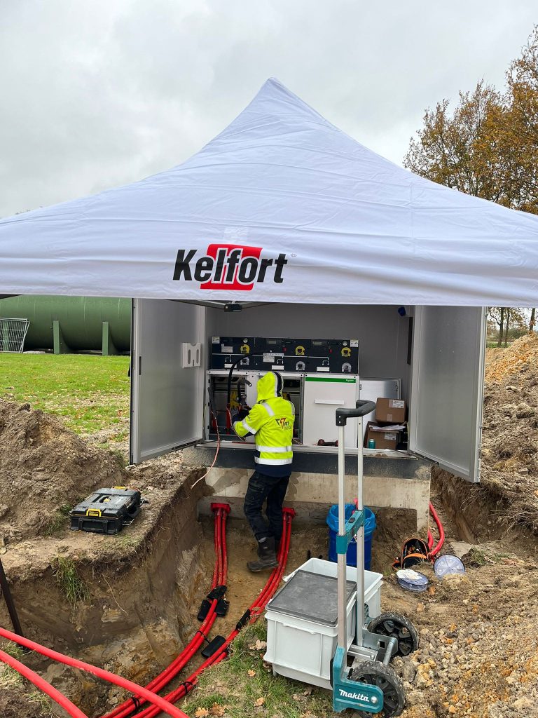 Monteur van DBT Energie sluit een compactstation aan