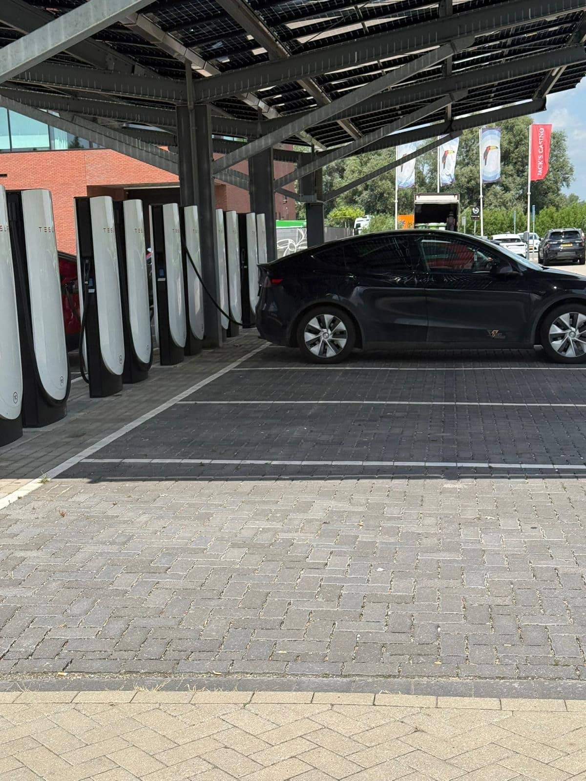 Laadplein met snelladers onder een overkapping met zonnepanelen